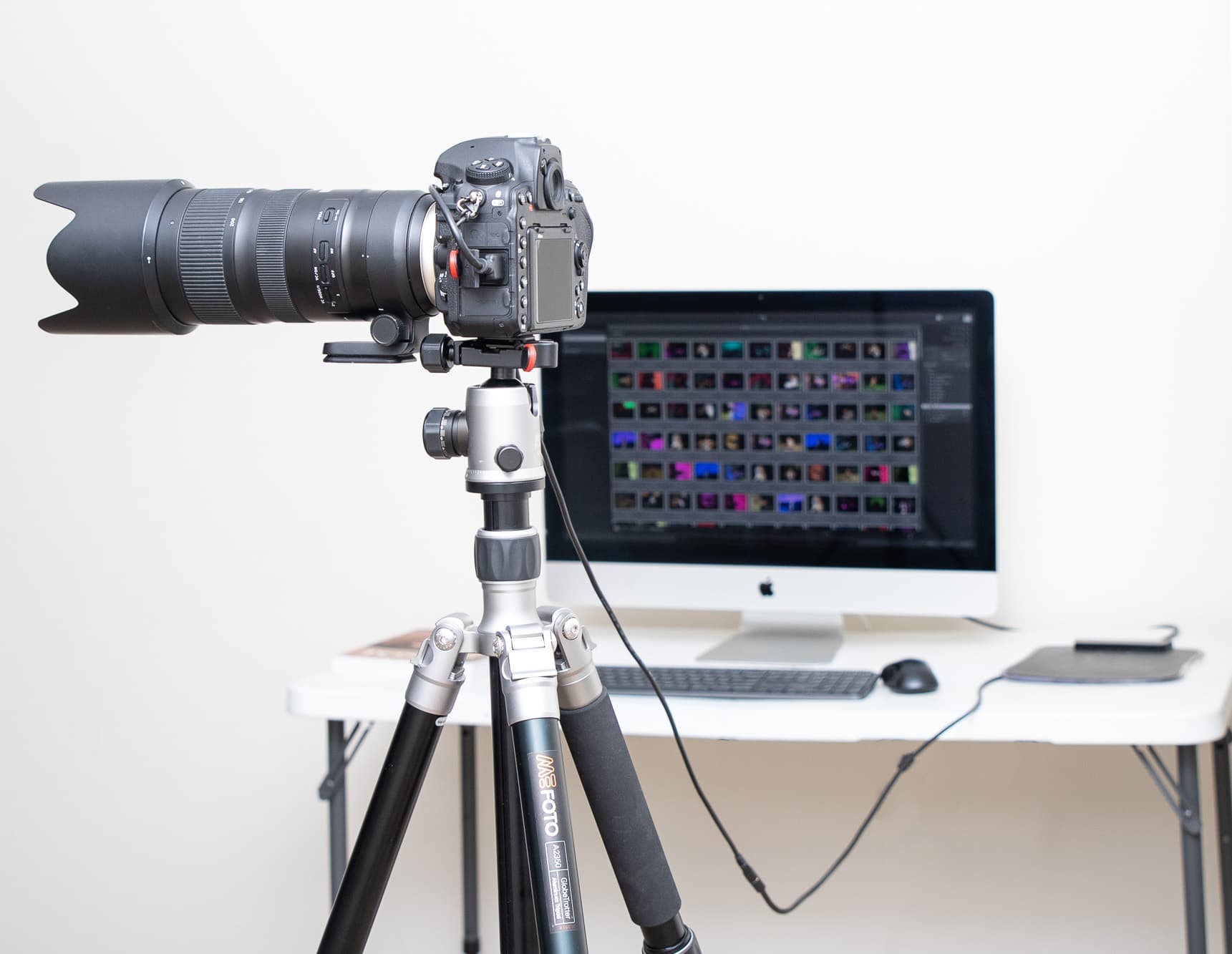 Chamara Perera Photography studio setup with camera on tripod, tethered to computer with cord for professional photography sessions